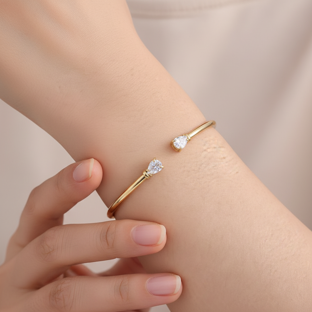 Bracciale rigido dorato indossato al polso