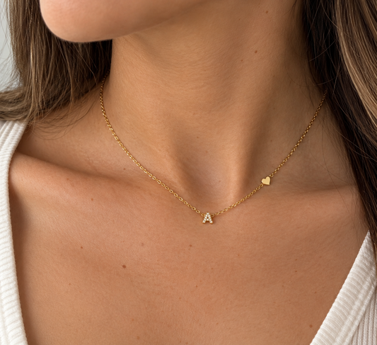 Collana Letterina gold indossata, con piccola iniziale A zirconata e mini cuore laterale sulla catena
