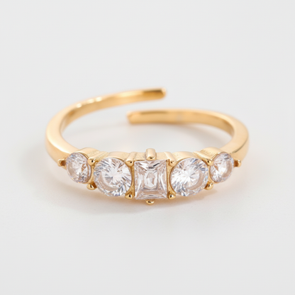 Anello dorato 5 cristalli sfondo grigio