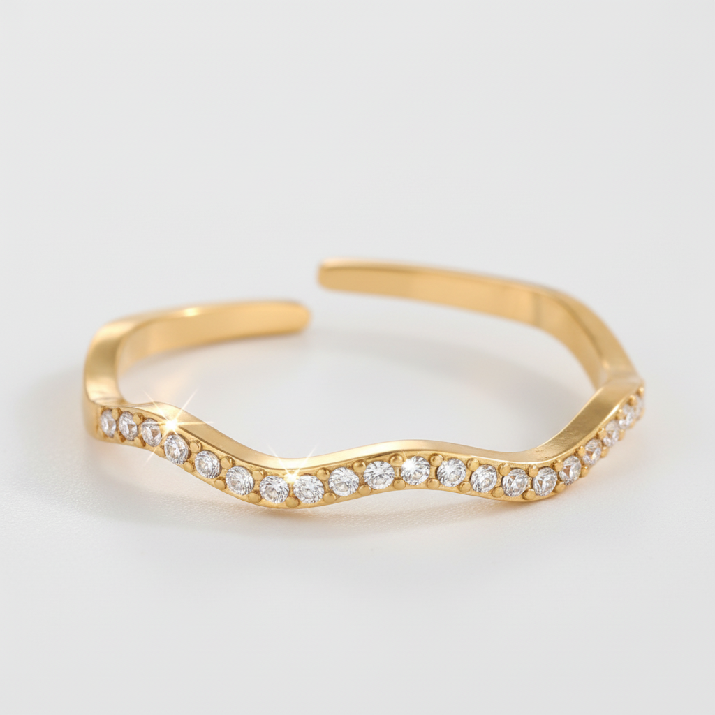 Anello ondulato dorato pavé sfondo grigio