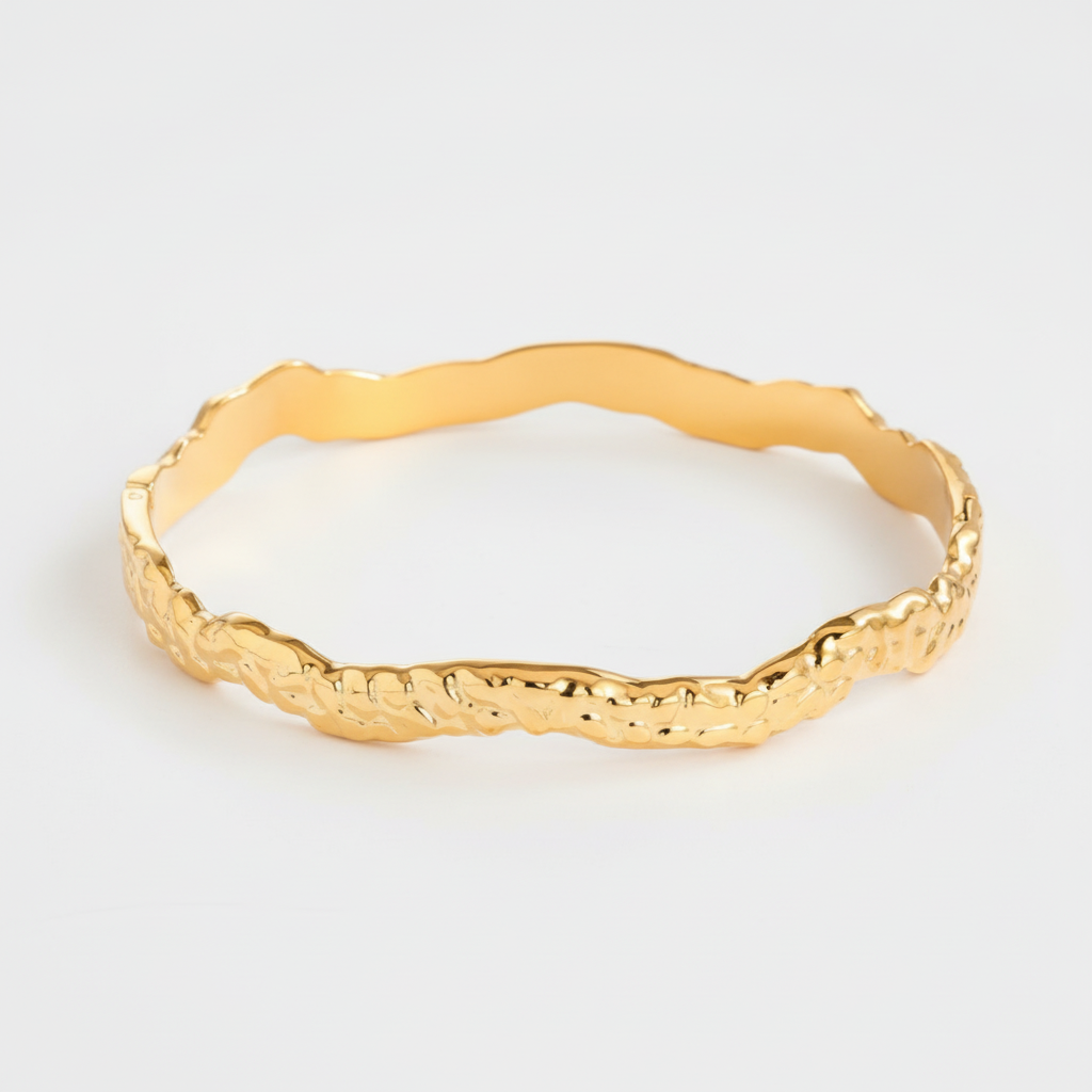 Bracciale rigido ondulato dorato sfondo grigio