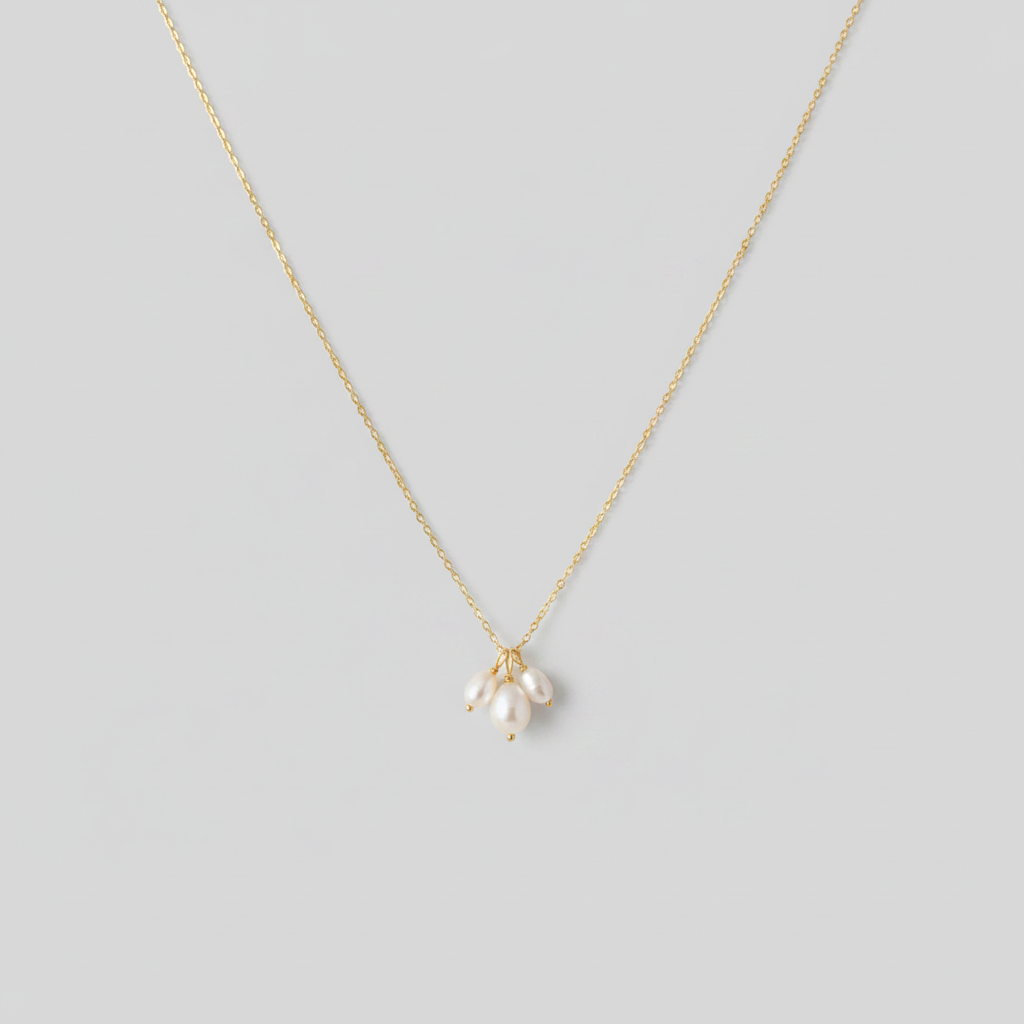 Collana gold tre perle - sfondo grigio chiaro piatto