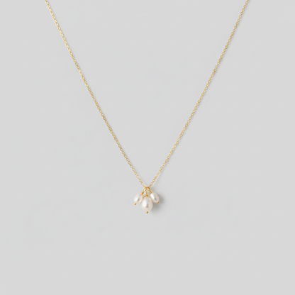 Collana gold tre perle - sfondo grigio chiaro piatto