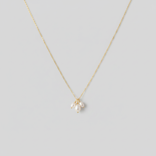 Collana gold tre perle - sfondo grigio chiaro piatto