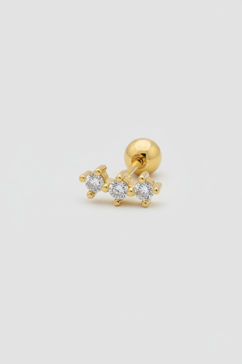 Piercing tre zirconi gold sfondo uniforme